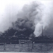 Hořící továrna Arbor.Vpravo je vidět budova nádraží.